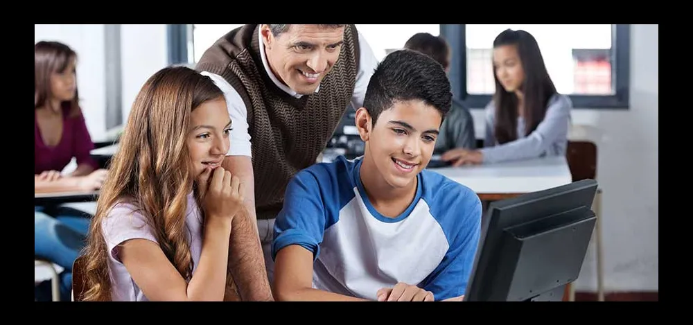 Middle school students and the teacher in front of a computer